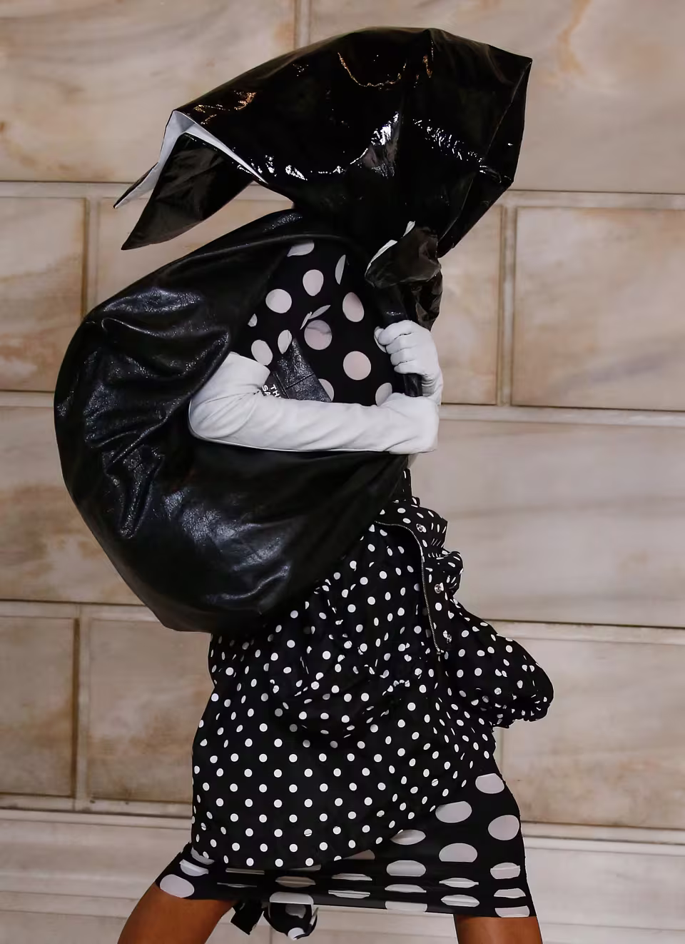 Runway model holding a black sack bag