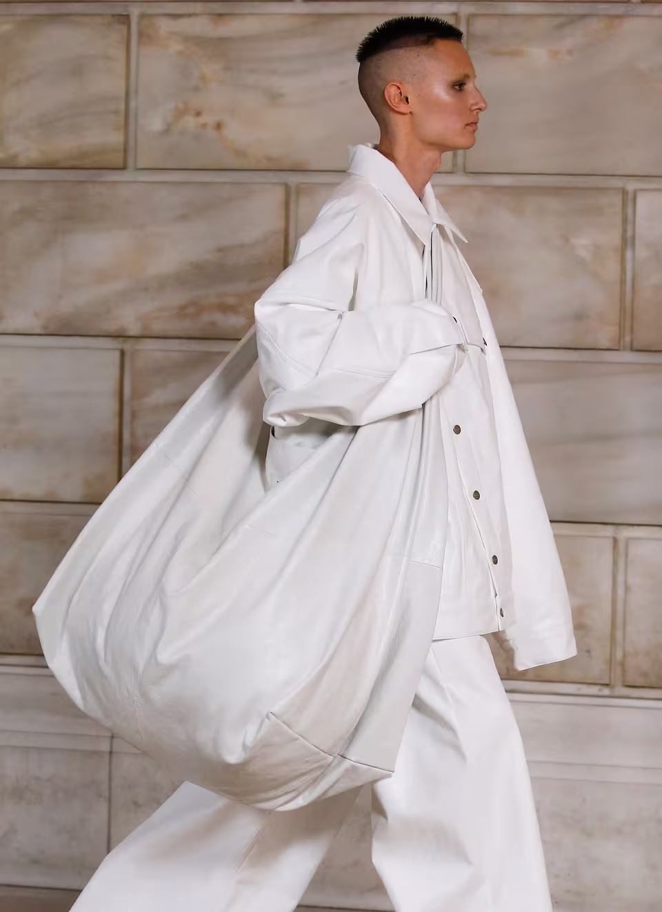 Runway model holding a big white sack bag